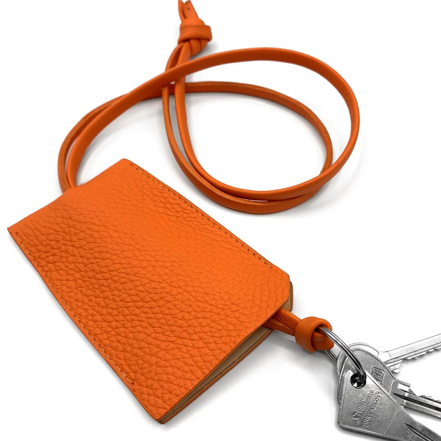 Un porte-cartes en cuir orange attaché à un cordon avec un jeu de clés.